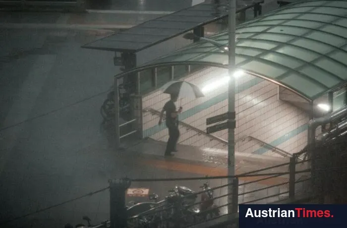 Person with umbrella enters subway